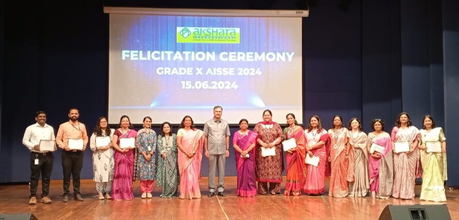 Students and faculties standing on stage with a certificate in hand