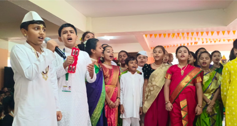 A diverse group of individuals in vibrant saris and kurtas singing joyfully together.